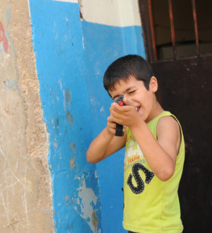 Beirut: Palestinian refugie boy shooting at enemies in Shatila. Ein palästinensischer Junge mit einer Spielzeugwaffe im Anschlag im Flüchtlingscamp Schatila.